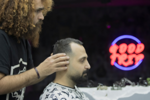 a man getting his hair cut at a barber shop — Foto por mostafa meraji na Unsplash