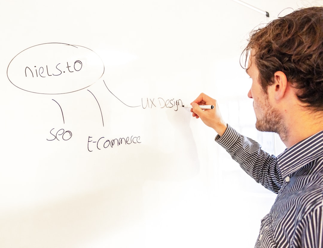 a man writing on a whiteboard — Foto por Niels Bosman na Unsplash