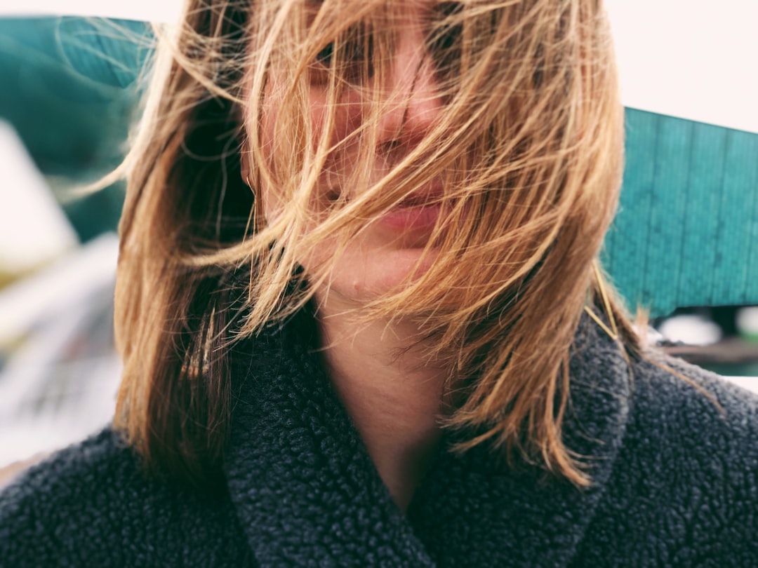 woman with black coat and hair in front of her face — Foto por Ekaterina Ivanova na Unsplash