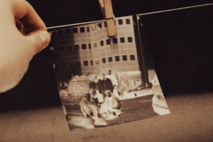 a hand holding a photo of two men and a dog — Foto por Jametlene Reskp na Unsplash