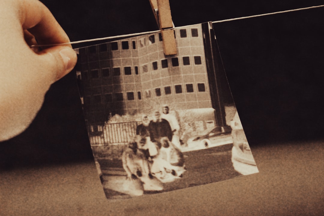 a hand holding a photo of two men and a dog — Foto por Jametlene Reskp na Unsplash