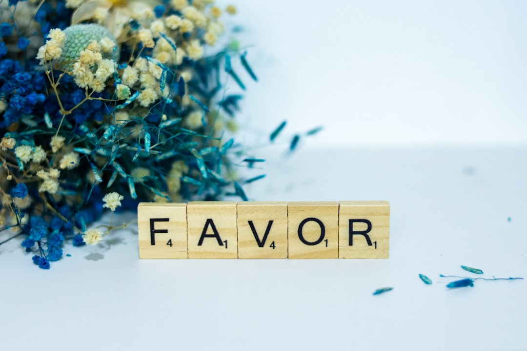 a wooden block that says flavor next to a bouquet of flowers — Foto por Alex Shute na Unsplash
