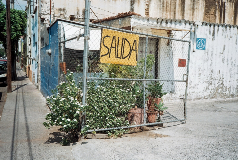 A fence with a sign that says sada on it — Foto por Evelyn Verdín na Unsplash