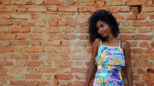 a woman standing in front of a brick wall — Foto por Eddie Santos na Unsplash