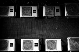 Eight air conditioning units mounted on a wall. — Foto por Volodymyr Kozhevnikov na Unsplash