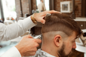 man in white dress shirt cutting hair of man — Foto por Michael DeMoya na Unsplash