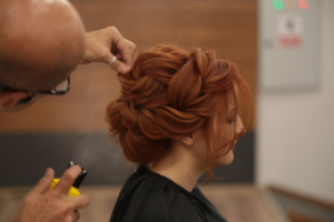 a woman getting her hair styled by a man — Foto por Enis Yavuz na Unsplash