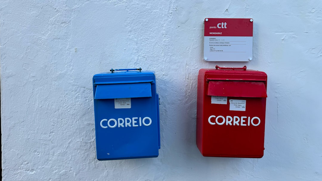a couple of red and blue mail boxes next to each other — Foto por Eddie Pipocas na Unsplash