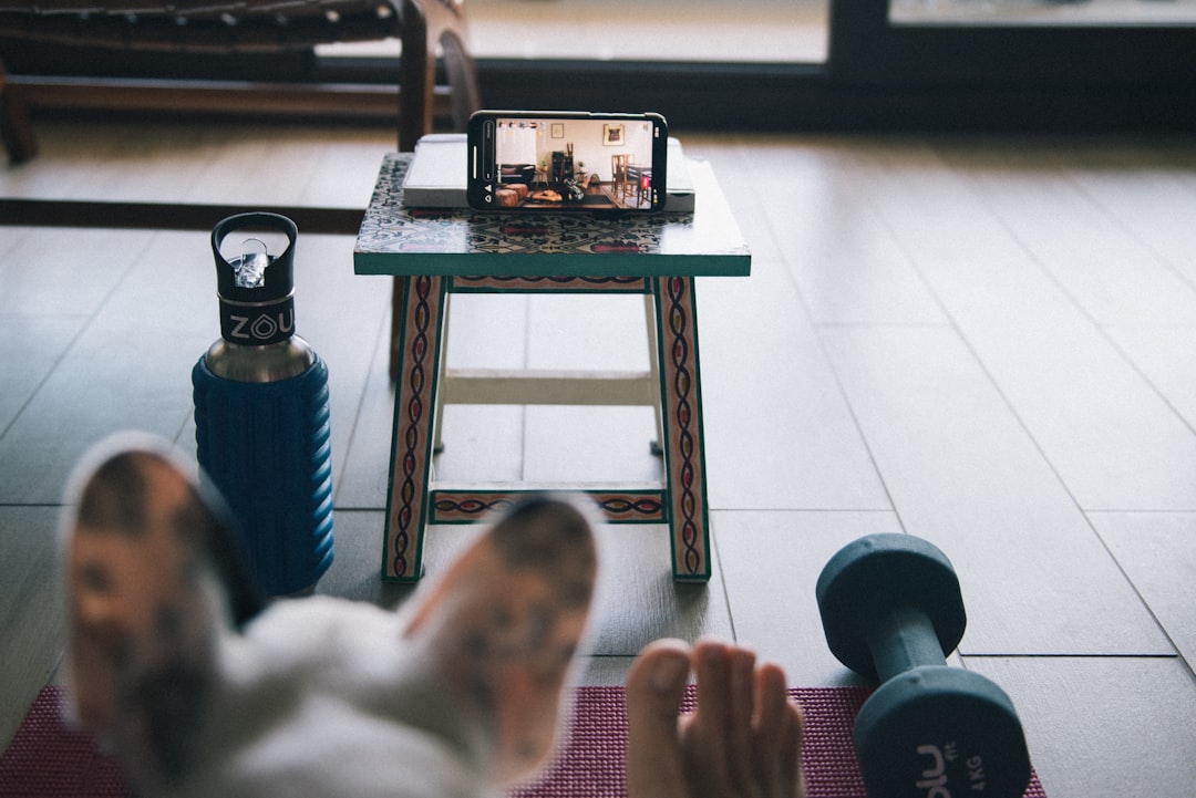 person in white pants sitting on blue and white striped couch — Foto por Maria Jesus Errazuriz na Unsplash